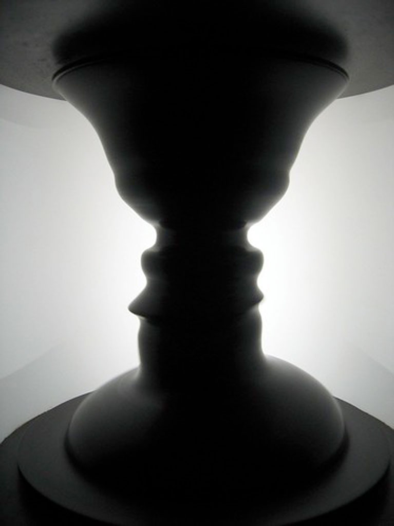 In the classic Rubin’s vase optical illusion, neurons in the brain must decide whether the border between black and white belongs to the white area or to the black area, which determines whether you perceive the scene as either a black vase on a white background, or white faces on a black background. Click here for a high-resolution image.